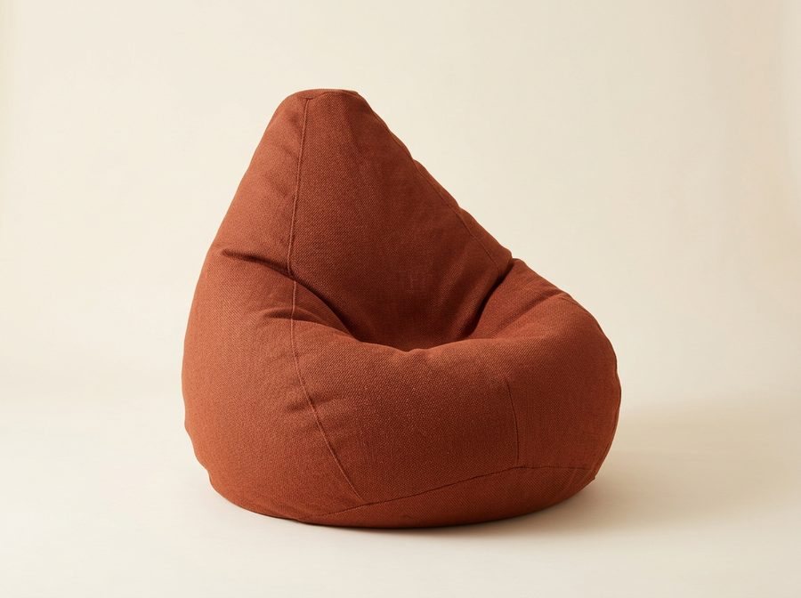 Fauteuil poire en tissu terracotta, en forme de goutte, creux d’assise marqué